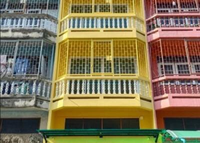 Colorful multi-story building with metal grilles
