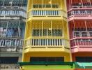 Colorful multi-story building with metal grilles