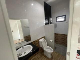 modern bathroom with toilet, sink, and window