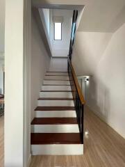 Staircase with wooden steps and handrail leading to upper floor