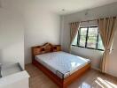 Bright bedroom with wooden bed and large window