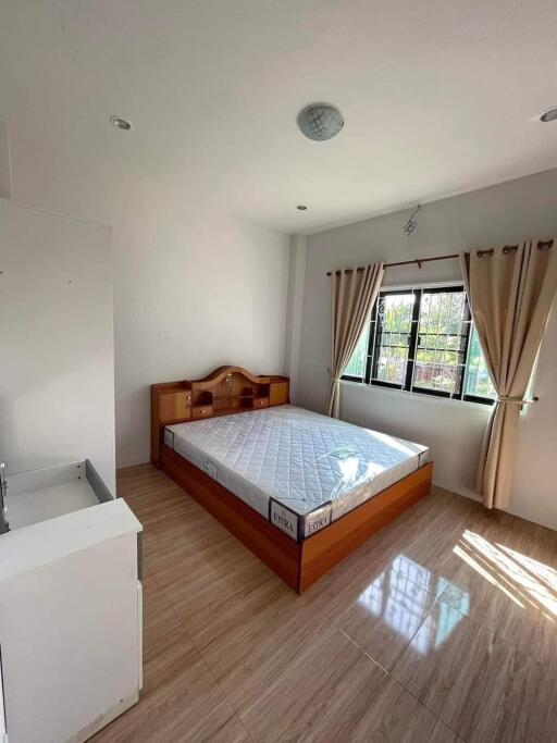 Bright bedroom with wooden bed and large window