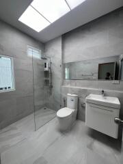 Contemporary bathroom with glass shower, toilet, and modern vanity