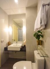 Modern bathroom with sink, mirror, and toilet