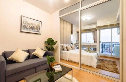 Living room with view into bedroom and balcony