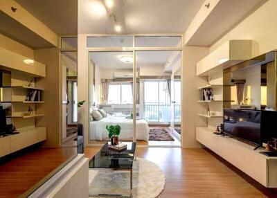 Modern living room with glass partitions leading to a bedroom