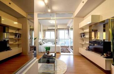 Modern living room with glass partitions leading to a bedroom