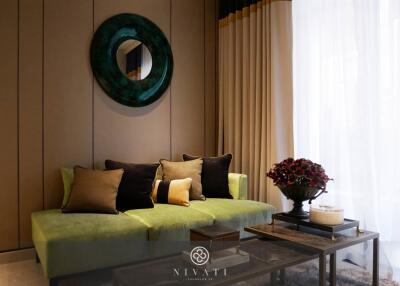 Modern living room with green sofa and decorative wall mirror