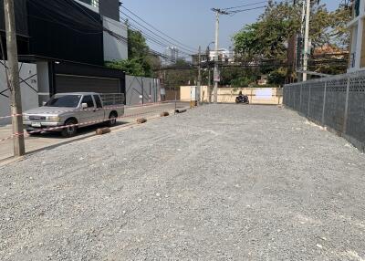 Gravel empty lot with parked vehicle and surrounding buildings