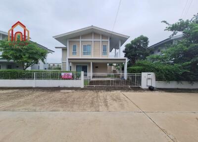 A two-story house exterior with a front yard and driveway