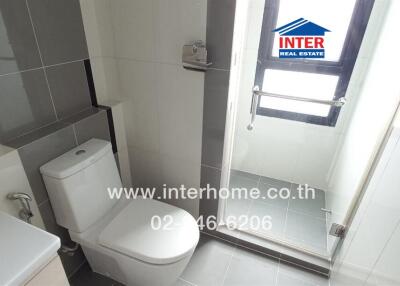 Modern bathroom with toilet, shower, and large window