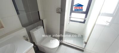 Modern bathroom with toilet, shower, and large window