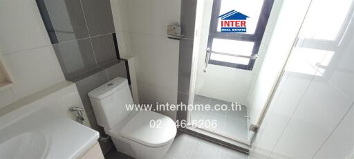 Modern bathroom with toilet, shower, and large window