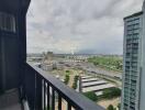 View from the balcony of a high-rise apartment showing a cityscape.