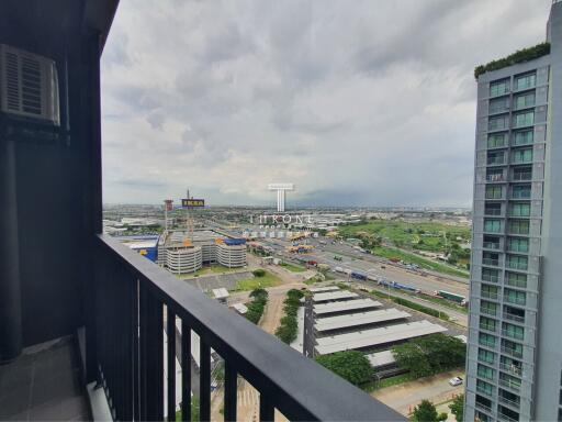 View from the balcony of a high-rise apartment showing a cityscape.