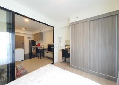 View of a studio apartment with open partitioned bedroom, kitchen, and dining area