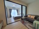 Modern living room with view into bedroom through glass sliding doors