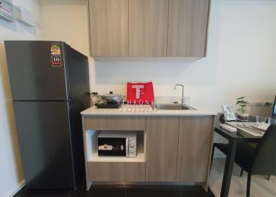 Modern kitchen with refrigerator, microwave, and dining area