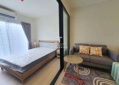 Bedroom view with a bed, sofa, table, and large sliding glass door