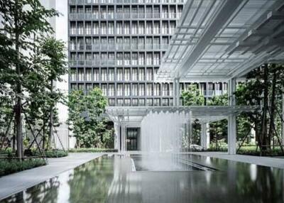 Modern high-rise building with water feature and landscaping