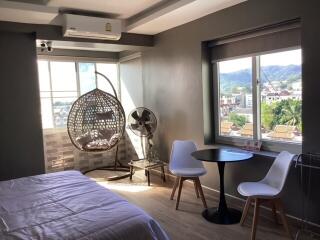 Bedroom with a hanging chair, table and chairs, window view