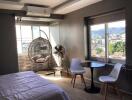 Bedroom with a hanging chair, table and chairs, window view