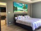 Bedroom with a large bed, tropical wall art, and adjacent living space