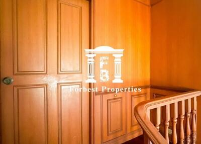 Hallway with wooden paneling and a closed door