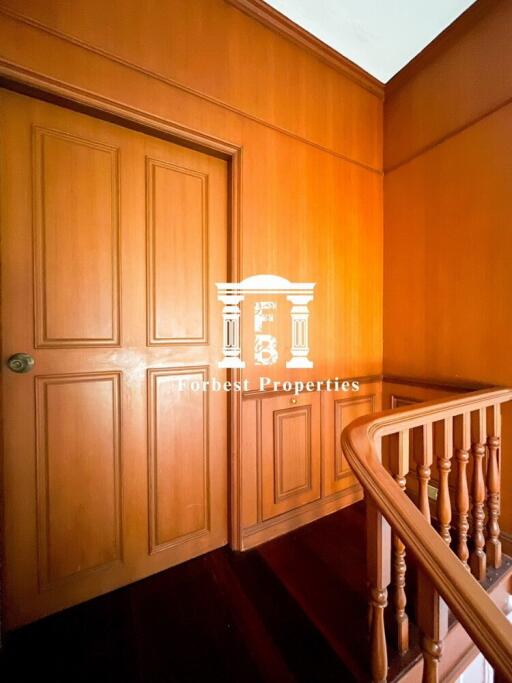 Hallway with wooden paneling and a closed door