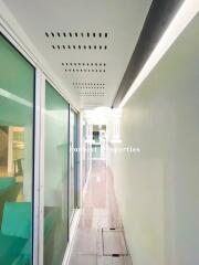 hallway with glass doors and wood flooring