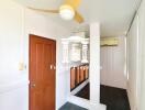 Room with orange door, ceiling fan, and air-conditioner