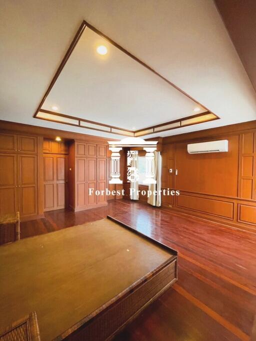 Spacious living room with wooden floors and paneling