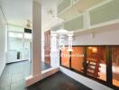 A spacious indoor area with a large window and frosted glass cabinets