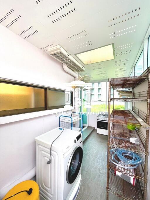 Laundry room with washing machine and shelving