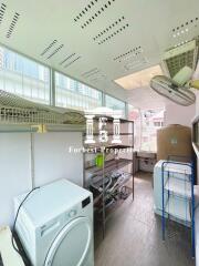 Utility room with storage shelves, washing machine, and ventilation