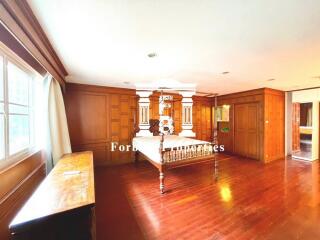 Spacious bedroom with wooden flooring and large windows