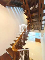 Wooden staircase with railings in a well-lit interior