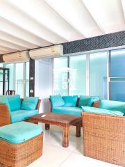 Modern living room with rattan furniture and turquoise cushions