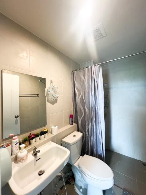 Modern bathroom with sink, toilet, and shower curtain