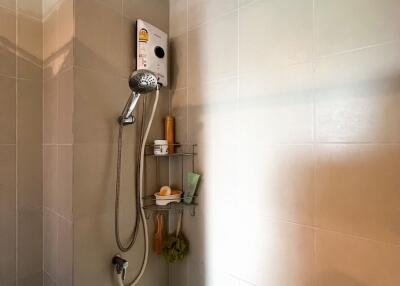 Shower area with tiled walls and storage shelf