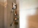 Shower area with tiled walls and storage shelf