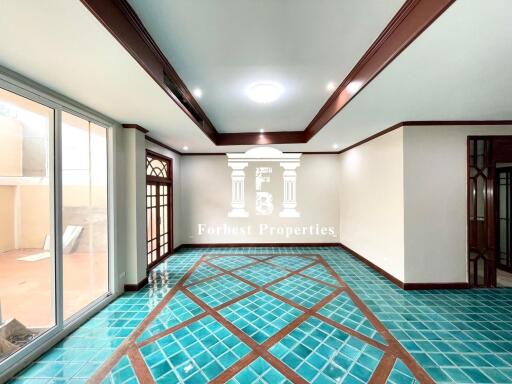 Spacious and well-lit living room with large windows and unique tile flooring