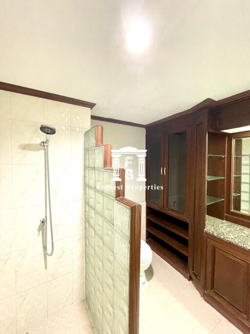 Bathroom with shower and wooden cabinets