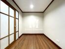 Empty room with wooden floor and frosted glass door