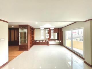 Spacious living room with large windows and built-in wooden shelves