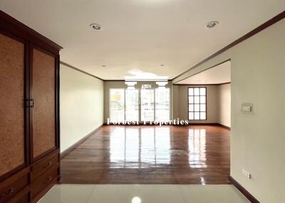 Spacious living area with wooden flooring and large windows