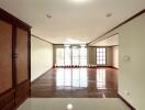 Spacious living area with wooden flooring and large windows