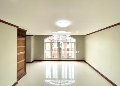 Spacious living room with large windows and built-in wooden shelves