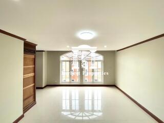 Spacious living room with large windows and built-in wooden shelves