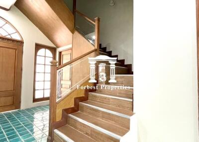 Staircase in a home with green tiled floor and wooden steps